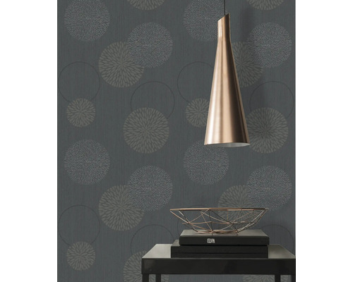 Gros plan d'un mur avec du papier peint à motifs floraux, une lampe et une table