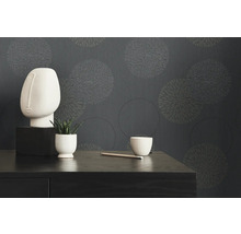 Objets de décoration devant un papier peint gris avec des motifs circulaires