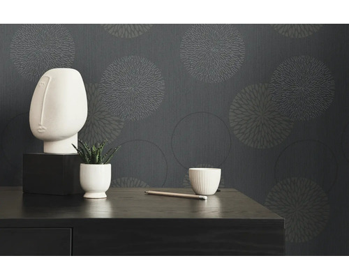 Objets de décoration devant un papier peint gris avec des motifs circulaires