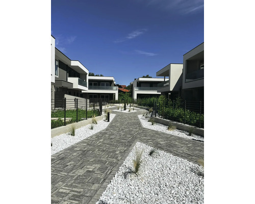 Szene mit Häusern, Pflastersteinen und Zierkies