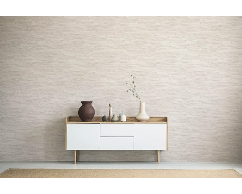 Salon avec commode, vases et objets décoratifs devant un mur à motifs