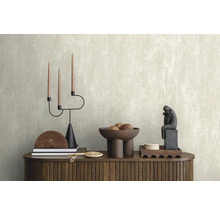 Arrangement décoratif sur une commode devant un papier peint structuré.