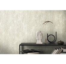 Espace de vie avec un papier peint mural de couleur claire avec un motif structuré, combiné à des éléments décoratifs sur une étagère.