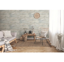 Salon avec papier peint à motifs, canapé et fauteuil sur un tapis