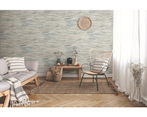 Salon avec papier peint à motifs, canapé et fauteuil sur un tapis