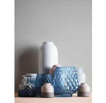 Anordnung verschiedener dekorativer Vasen aus Glas und Keramik