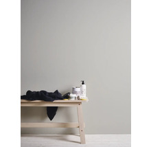 Helle, freundliche Badezimmerszene mit Holzbank, Badtextilien und Pflegeprodukten