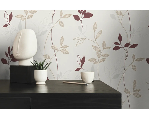 Dekorative Wand mit Tapete mit Blattmuster, minimalistische Skulptur und Zimmerpflanze