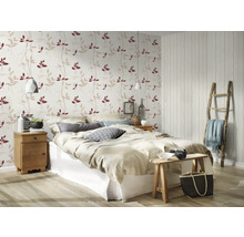 Schlafzimmer mit Bett, Nachttisch und Tapete mit Blattmuster