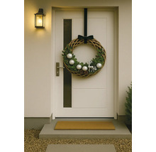 Couronne de porte décorative avec motifs de Noël sur une porte d'entrée