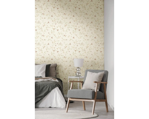 Schlafzimmer mit blumiger Tapete, Bett und Sessel