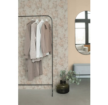 Porte-vêtements avec vêtements, miroir et décoration dans une pièce.