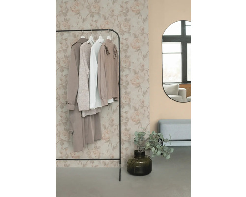 Porte-vêtements avec vêtements, miroir et décoration dans une pièce.