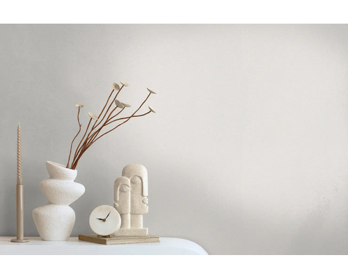 Arrangement décoratif avec vase, horloge, bougie et sculpture sur une surface.