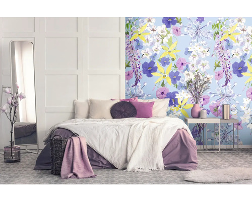 Schlafzimmer mit Doppelbett, Spiegel, Nachttisch und floraler Tapete