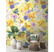 Intérieur décoratif avec papier peint jaune, orné de fleurs, de papillons et d'oiseaux, complété par un fauteuil en rotin et des plantes d'intérieur