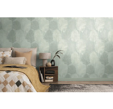 Chambre avec papier peint à motifs et un lit avec des coussins et une couverture