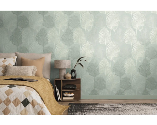 Chambre avec papier peint à motifs et un lit avec des coussins et une couverture