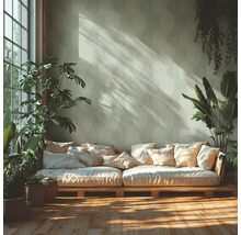 Pièce lumineuse avec canapé en palettes, coussins et plantes d'intérieur
