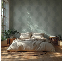 Chambre claire avec papier peint à motifs, lit, tables de chevet et plantes
