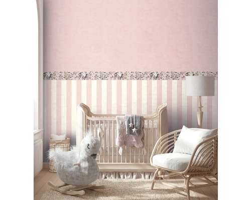 Chambre de bébé avec lit à barreaux, cheval à bascule et fauteuil en rotin