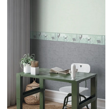 Chambre d'enfant décorative avec bureau, chaise et bordure de papier peint sur le thème de la forêt.
