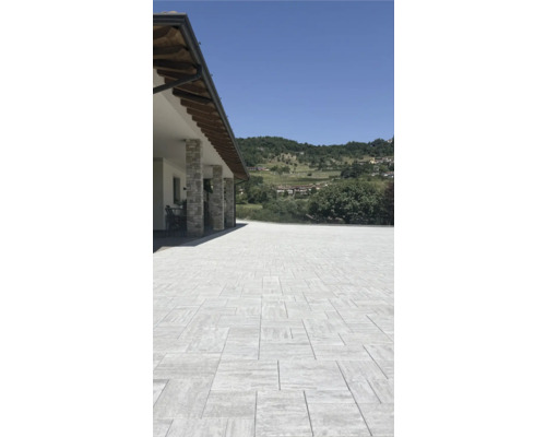 Terrasse avec pavage clair et maison avec piliers en pierre