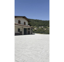 Espace extérieur avec pavés devant une maison à flanc de colline