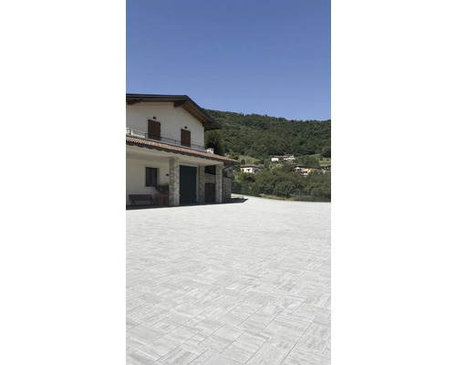 Espace extérieur avec pavés devant une maison à flanc de colline