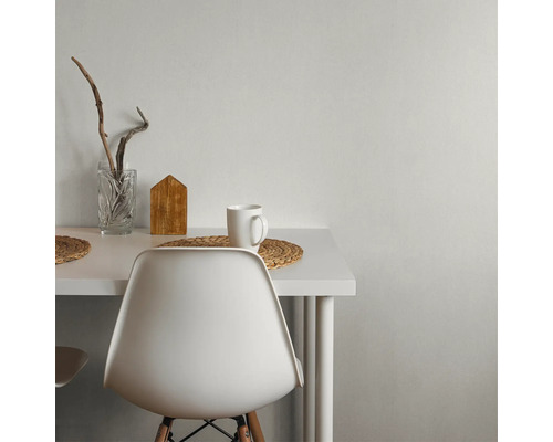 Table blanche avec décorations, dont un verre, une maison en bois et une tasse