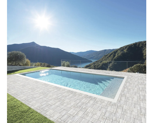 Piscine avec bordure de dalles en pierre à l'extérieur