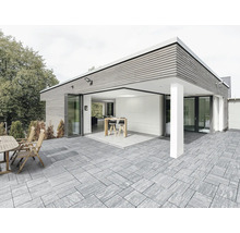 Extérieur avec maison moderne, terrasse avec dalles en pierre, coin salon et bar avec tabourets de bar