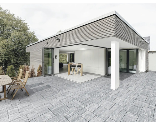 Extérieur avec maison moderne, terrasse avec dalles en pierre, coin salon et bar avec tabourets de bar