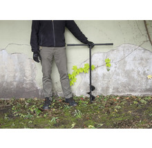 Personne avec tarière dans le jardin