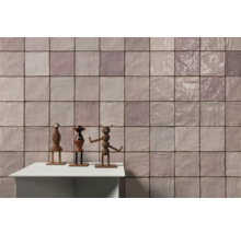 Fliesenwand mit Spielzeugfiguren auf einem Tisch