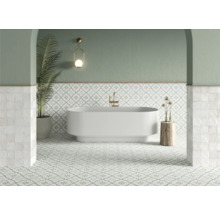 Badezimmer mit Badewanne, Fliesenboden und Wandleuchte