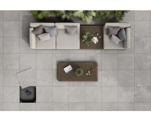 Vue de dessus d'une terrasse avec des dalles de terrasse gris clair, des meubles de salon et des tables en bois