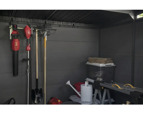 Intérieur d'abri de jardin avec outils de jardinage, boîtes de rangement et établi