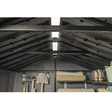 Vue intérieure d'un abri de jardin avec des étagères, des outils et de l'éclairage