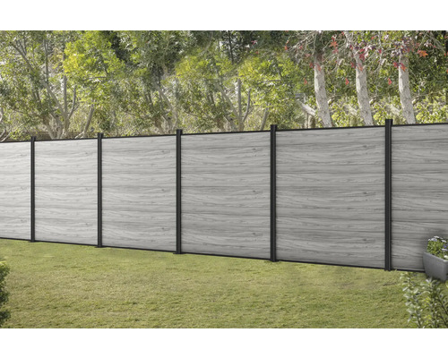 Grauer Holzzaun mit schwarzen Pfosten im Garten.