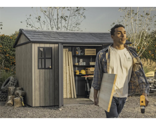 Abri de jardin avec porte ouverte et une personne transportant des outils et du bois