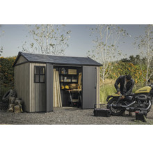 Abri de jardin avec portes ouvertes, outils et moto dans le jardin