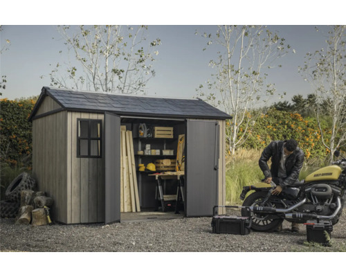 Abri de jardin avec portes ouvertes, outils et moto dans le jardin