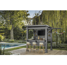 Dans le jardin, un pavillon avec bar, tabourets et décoration est installé à côté d'une piscine.