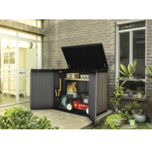 Armoire à outils ouverte avec outils de jardinage et tondeuse à gazon