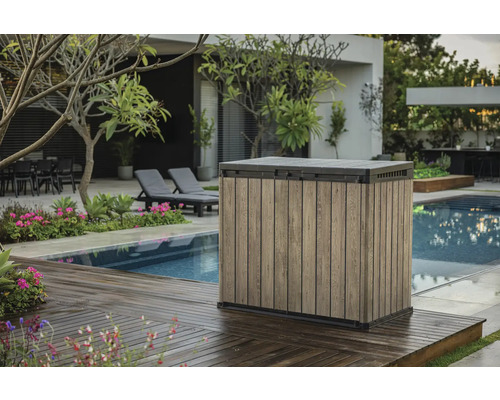 Scène de jardin avec un coffre de rangement à côté d'une piscine sur une terrasse en bois.