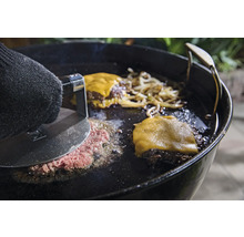 Préparation de hamburgers sur une plaque de cuisson avec presse à hamburger, fromage et oignons