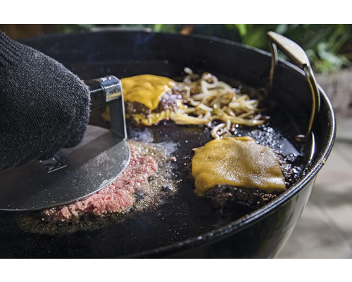 Préparation de hamburgers sur une plaque de cuisson avec presse à hamburger, fromage et oignons