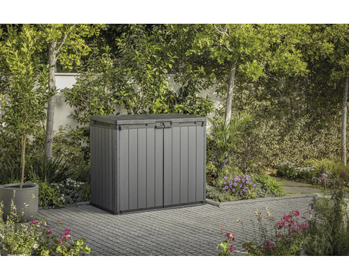 Graue Gerätebox im Garten mit umliegender Vegetation