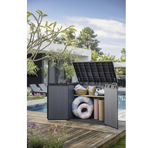 Geöffnete Gartenbox aus Kunststoff auf einer Holzterrasse, gefüllt mit Gartenzubehör